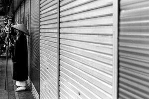 Buddhist monk standing in front of shutter