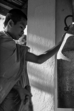 Young monk striking bell