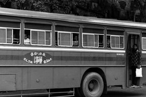 Bearded man standing on platform of bus