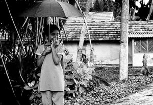 雨の中で傘を片手にウインクする女の子