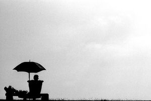 SIlhouetted man relaxing under sunshade