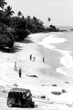 Boys playing football on sand beach