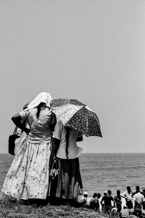 Women watching fishermen working on beach
