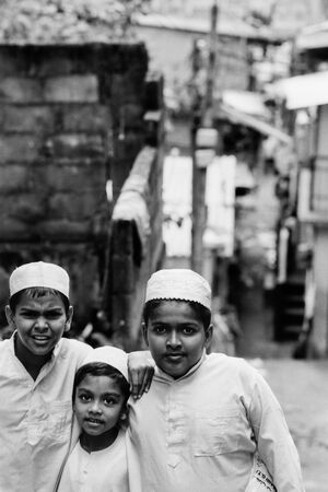 Three boys wearing white Taqiyah