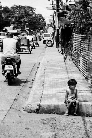 Girl sitting on sidewalk alone