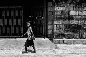 Boy walking under strong sun