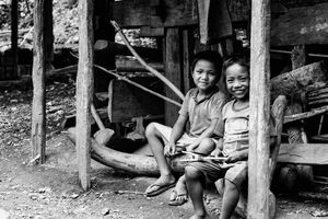 Two boys sitting on edge of eaves