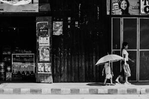 Little girl putting big umbrella up