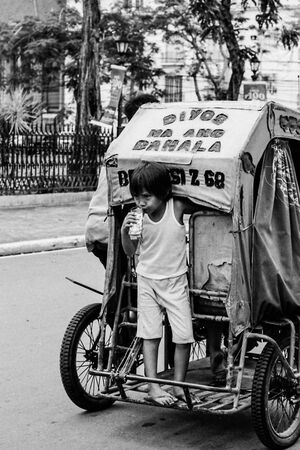 Boy getting on back of tricycle