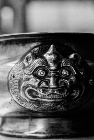 grotesque face sculptured on bowl