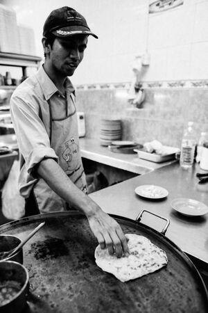 鉄板でチャパティを焼く男