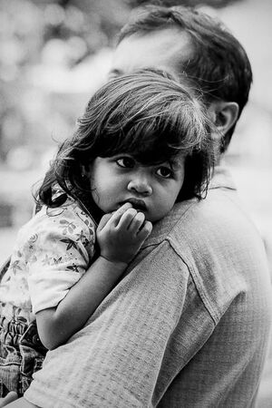 Little girl being held in father\'s arms