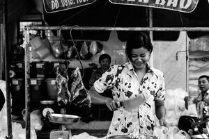Young female butcher cutting meat