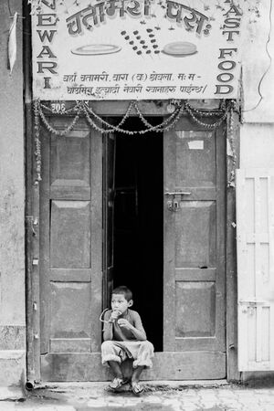 Boy sitting in front of restaurant