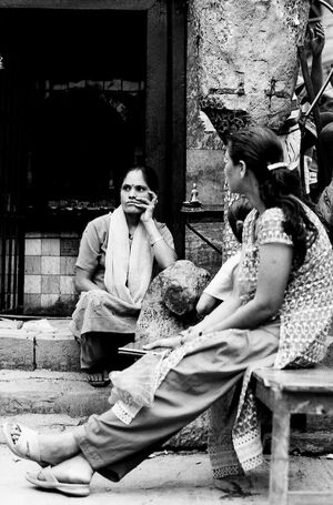 Women sitting in front of small Hindu shrine