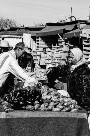 Woman with a hijab buying potatoes