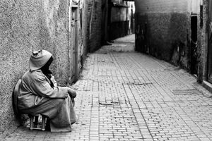 Woman sitting in an empty Marrakesh alley