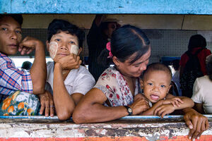 Passengers leaning out of the car window of Yangon Circular Railway