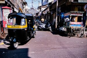 Auto rickshaw running street corner