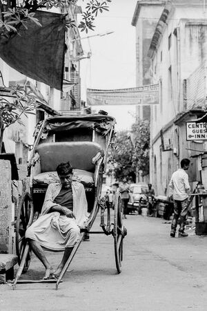 Rickshaw wallah looking lifeless on his vehicle