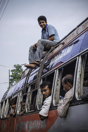 バスの屋根の上に座る青年