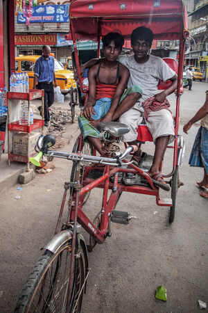Two men sitting on the seat of the cycle rickshaw