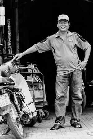 バイクの横で微笑む男