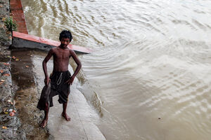 Young man standing on edge of water of Hooghly river