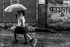 Two girls in rain with umbrella
