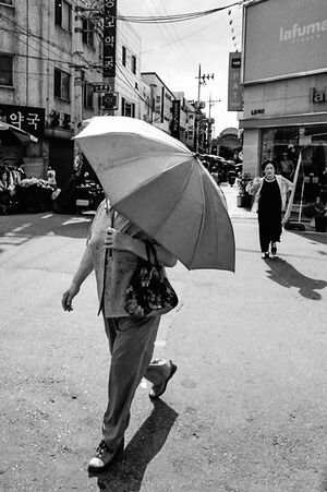 傘を差して歩く小太りの女