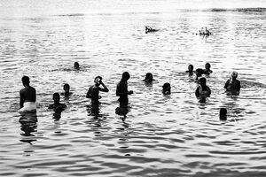 Silhouetted people soaking in Mahananda river