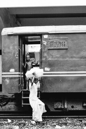 boy on platform and man carrying burden