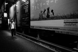 広告の横を歩く男