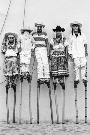 Boys wearing tall stilts