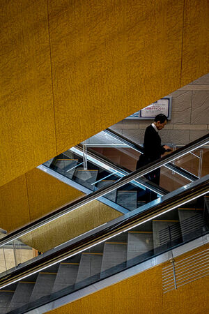 Businessman wearing a business suit on escalator