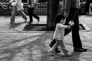 花を持って歩く幼い女の子