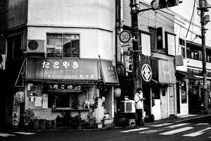 young man beside Takoyaki shop