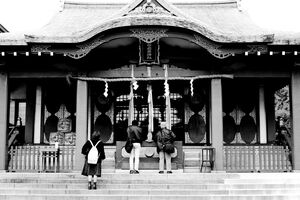Three worshiper in front of shrine