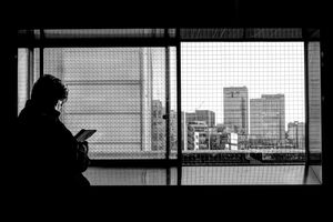Silhouetted man by window