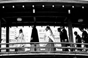 木製の橋を渡る結婚式の参列者