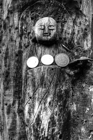wooden Buddha statue and coins