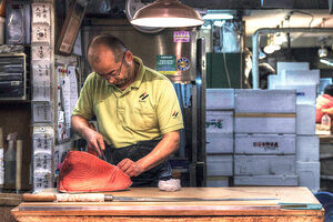 Man cutting tuna block