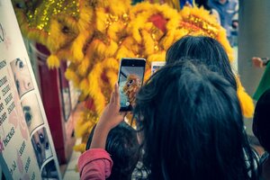 獅子舞の獅子の写真を撮る子どもたち