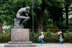 Parent and child taking a picture in front of the thinker