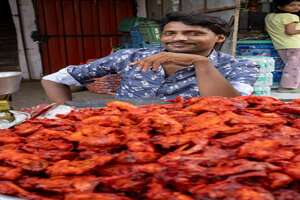 Man selling bright red food