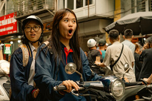Girl riding off on a motorbike with her mouth wide open