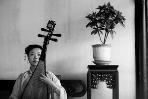 Woman playing Chinese lute with deadpan face