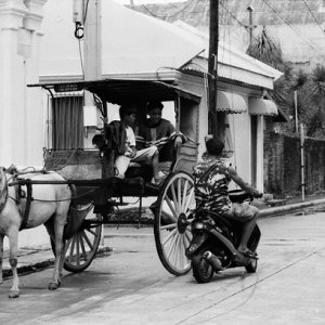 Motorbike stopping beside horse carriage