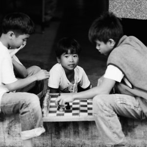 Boys playing chess by roadside