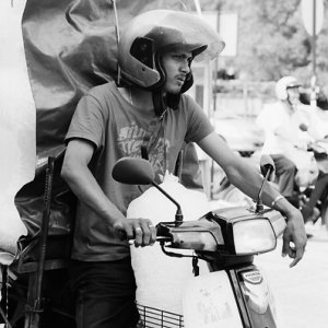 Men carrying big burden with motorbike